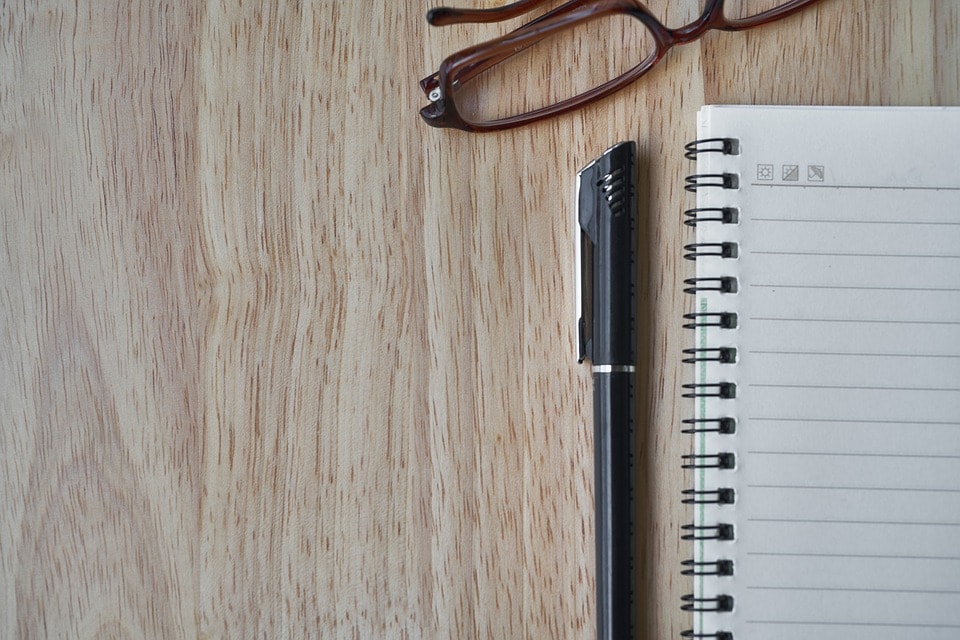 Pen, briller og notesbog